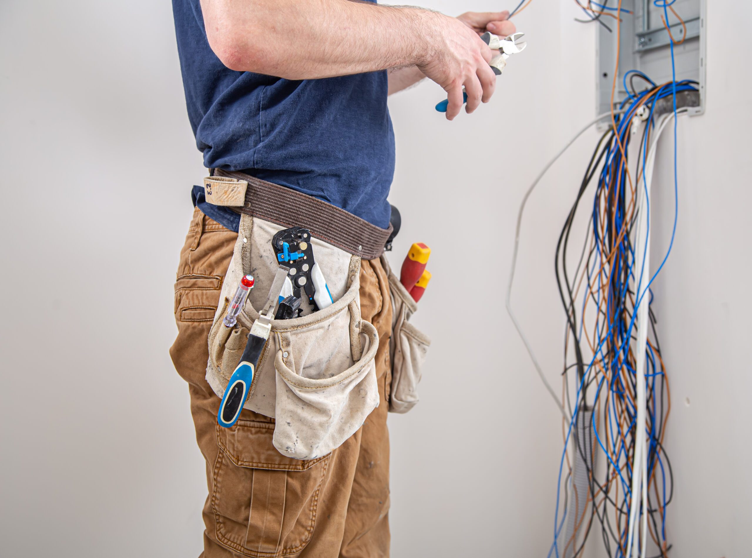 electrician builder work examines cable connection electrical line fuselage industrial switchboard professional overalls with electrician s tool scaled